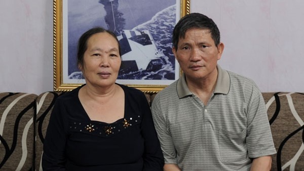 Vợ chồng bác Phạm Quang Tiến và Hà Thị Nhiên bên bức ảnh “Sự trừng phạt đích đáng” tại nhà riêng.