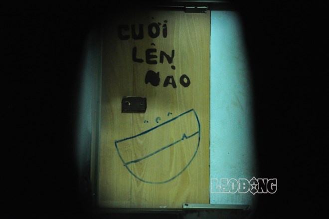 Trong ngôi nhà, dưới gầm cầu thang nhìn qua khe cửa là dòng chữ và hình vẽ của Thủy - con gái bà Dung.
