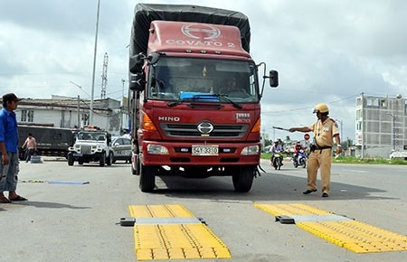 Nhiều nhóm xe tải chở hàng được đề nghị phải có thùng xe theo chuẩn nhằm kiểm soát tải trọng. Trong ảnh: CSGT TP.HCM cân, kiểm tra xe quá tải.