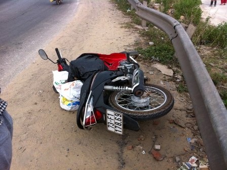 Chiếc xe máy bị cánh cửa xe khách BKS 29B-02430 gạt  văng ra xa.