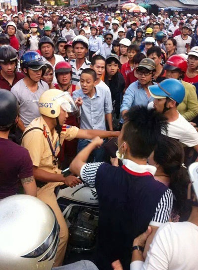 Hàng trăm người dân vây quanh cảnh sát giao thông.