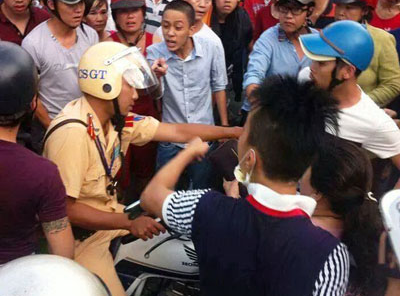 Canh sat giao thong bi nhieu nguoi vay danh hinh anh