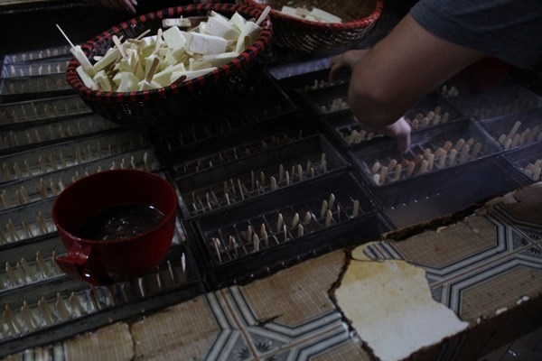 Những que kem này đang được công nhân nhúng vào ca phẩm tạo màu sôcôla.