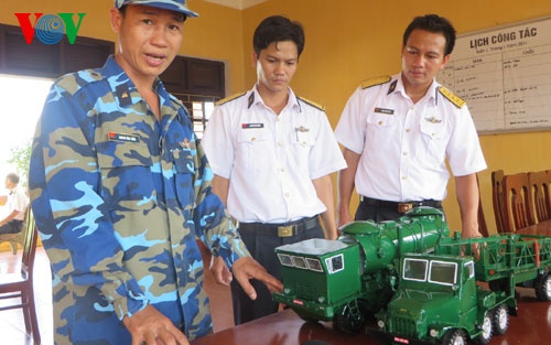 Trung úy chuyên nghiệp Hoàng Văn Tuấn, đội Hỏa lực, Lữ đoàn 679 đang giới thiệu về mô hình xe nạp đạn, xe bệ phóng tên lửa.