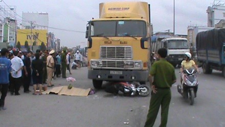 Hai ong chau bi xe keo container cuon vao gam hinh anh