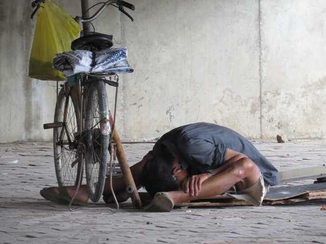 Một đối tượng nghiện phê ma túy đang gục đầu xuống đất ngay dưới gầm cầu đường bộ Tam Bạc.