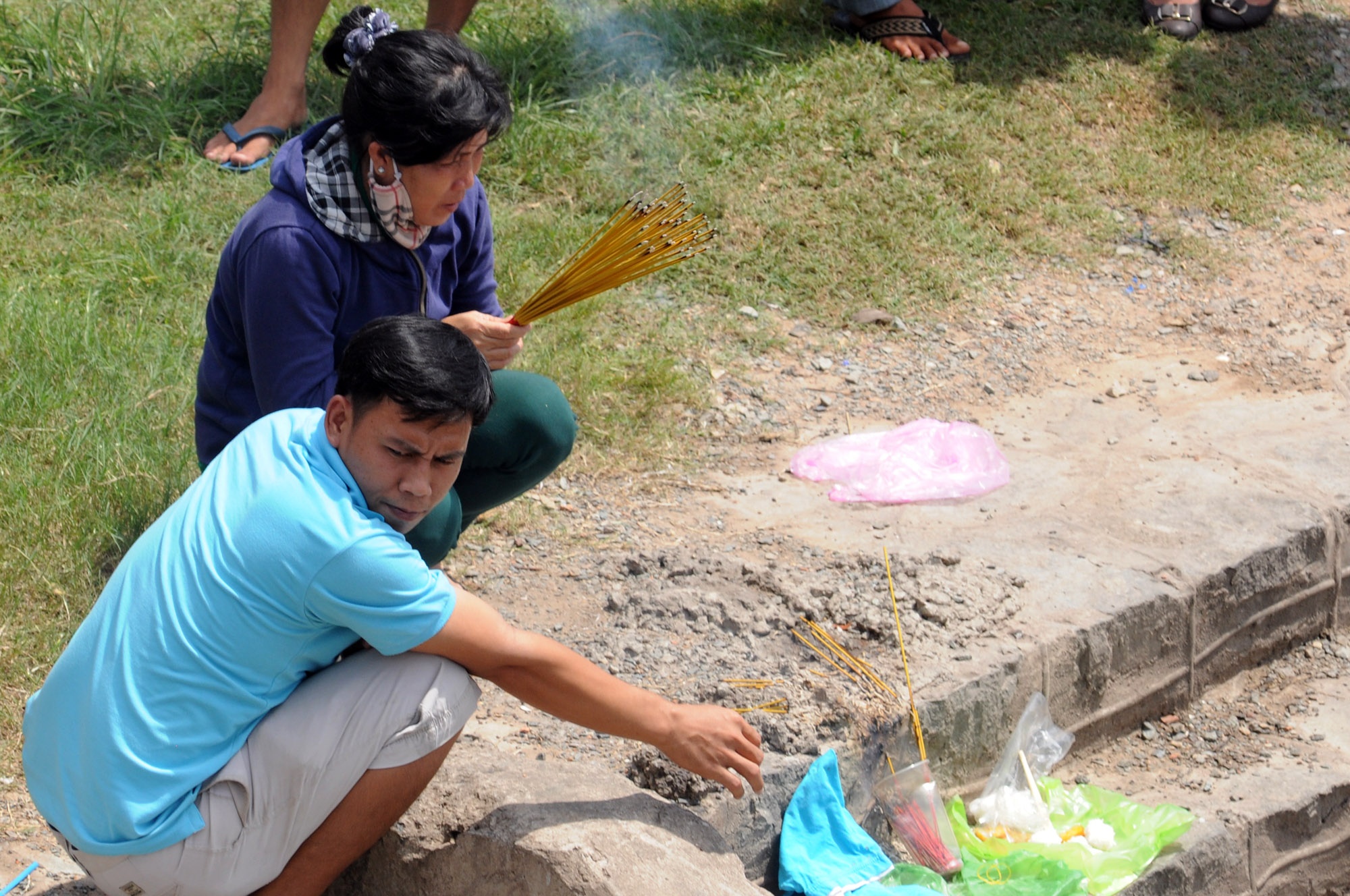 Người nhà nhắp nhang cầu khấn bên bờ kênh.