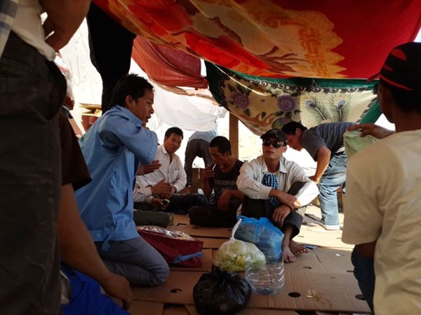 Các lao động lấy chăn màn để quây thành lều.