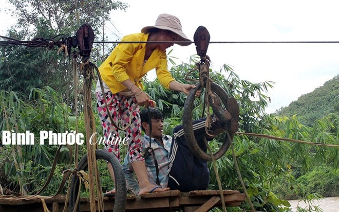 Mỗi lần qua lại, phải chui người qua vỏ xe máy nối với ròng rọc.