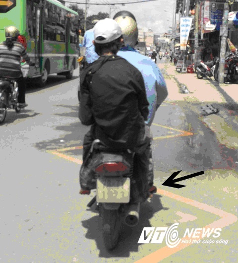 Đông ngồi xe máy như người bình thường (mũi tên đen) không hề giống bại liệt  