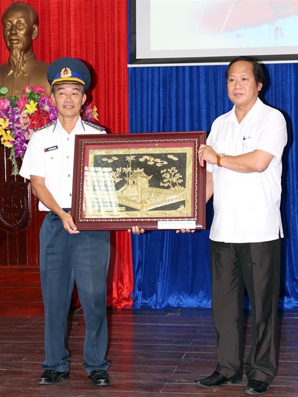 Ông Trương Minh Tuấn (phải) tặng bức tranh cho đại tá Nguyễn Ngọc Lân, phó chỉ huy trưởng - tham mưu trưởng Vùng Cảnh sát 3.