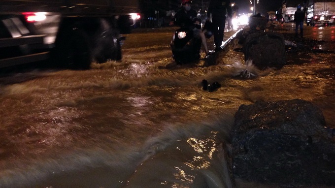 Nước quá lớn, người dân phải tháo dải phân cách để thoát nước.