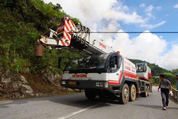 Sau khoảng 30 phút kéo hai sợi dây cáp và móc nối vào thân xe, phần nóc xe đã được kéo lên mặt đường. 