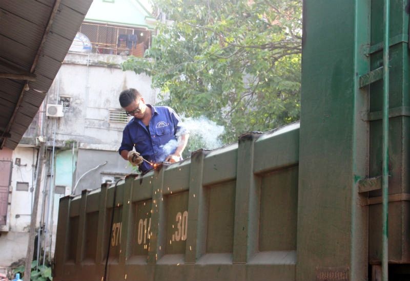 Thợ cơ khí cắt gọt thùng xe bằng cách dùng hàn xì. Mỗi ngày, một người thợ làm cật lực cũng chỉ hạ được 1-2 thùng xe ‘Hổ vồ’ quá khổ.