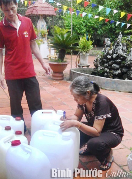 Ghi bệnh án lên can nước trước khi thánh mẫu làm phép.