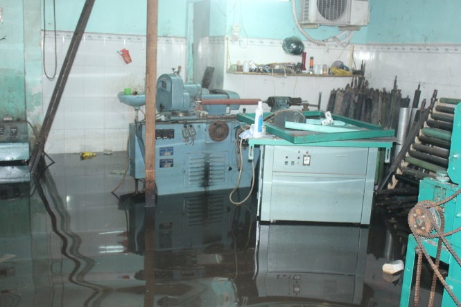 Sáng 2-10, máy móc của cơ sở cơ khí Lập Vinh ở đường Chiến Lược (quận Bình Tân, TP.HCM) vẫn còn ngập trong nước.