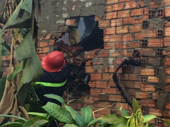 Lính cứu hỏa phải phá tường tiếp cận dập lửa.