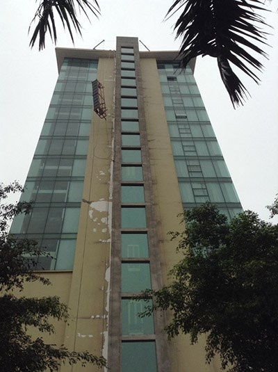 Bục đứng của hai công nhân vẫn còn treo lơ lửng ngang tầng thứ 12 của tòa nhà 14 tầng.