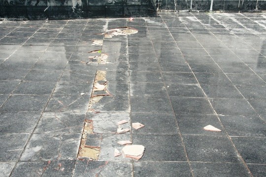 Gạch bị bong tróc một đường dài phía dưới chân tượng đài.