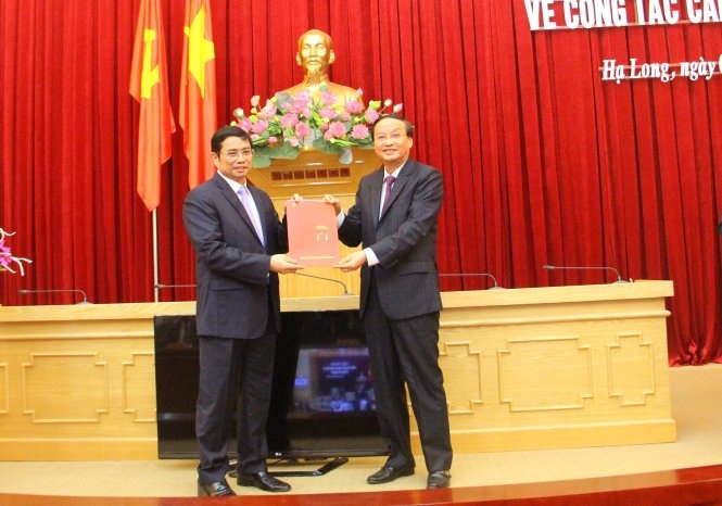 Ông Tô Huy Rứa (phải) - trưởng Ban Tổ chức trung ương - trao quyết định phân công ông Phạm Minh Chính, nguyên Bí thư Tỉnh ủy Quảng Ninh, giữ chức phó trưởng Ban tổ chức trung ương.