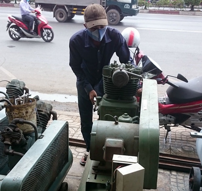 Nhân viên một cửa hàng điện cơ chạy thử máy bơm vá ôtô “nghĩa địa” cho khách xem.