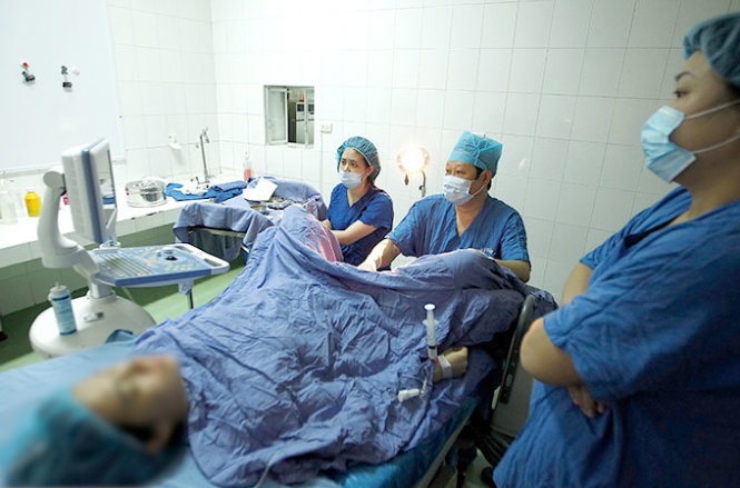 Thứ trưởng Bộ Y tế kiêm giám đốc Trung tâm Hỗ trợ sinh sản quốc gia Nguyễn Viết Tiến (giữa) thao tác trong một ca phẫu thuật.