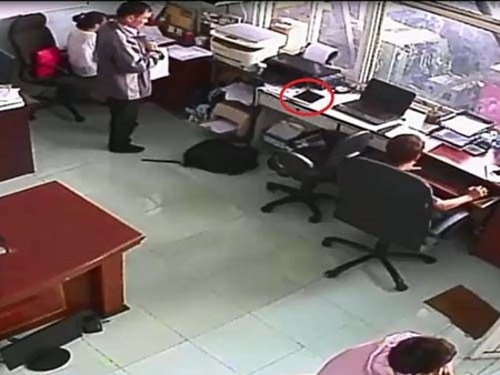 Tên trộm đang tăm tia chiếc iPad để trên bàn (ảnh cắt từ clip).