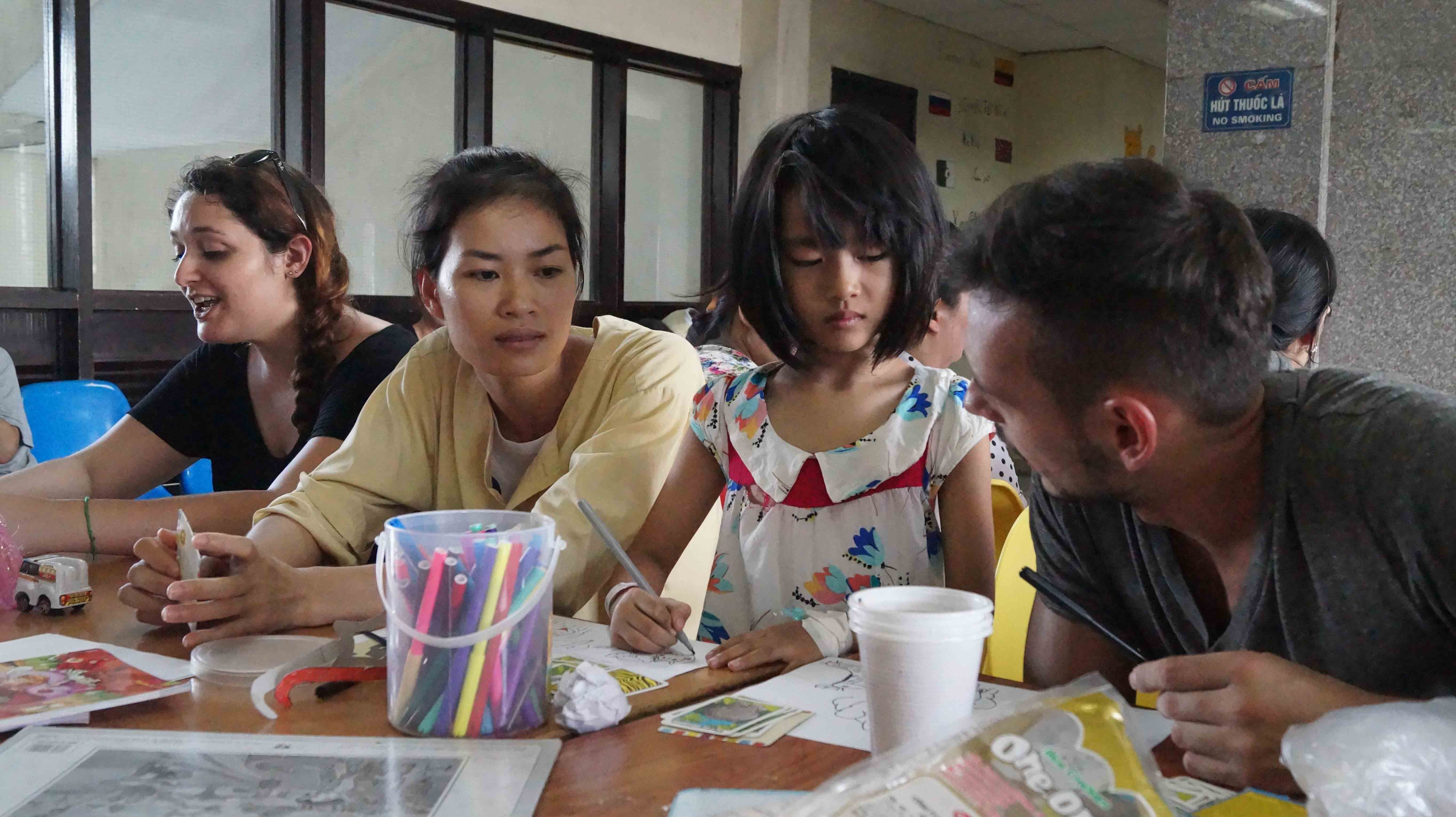 Adele và David đang trò chuyện với bệnh nhi và phụ huynh.