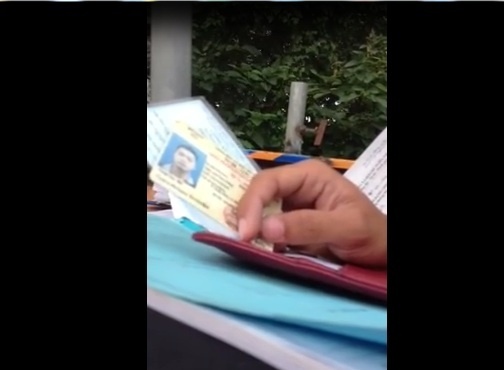 CSGT cầm giấy tờ của người dân. Ảnh cắt ra từ clip.