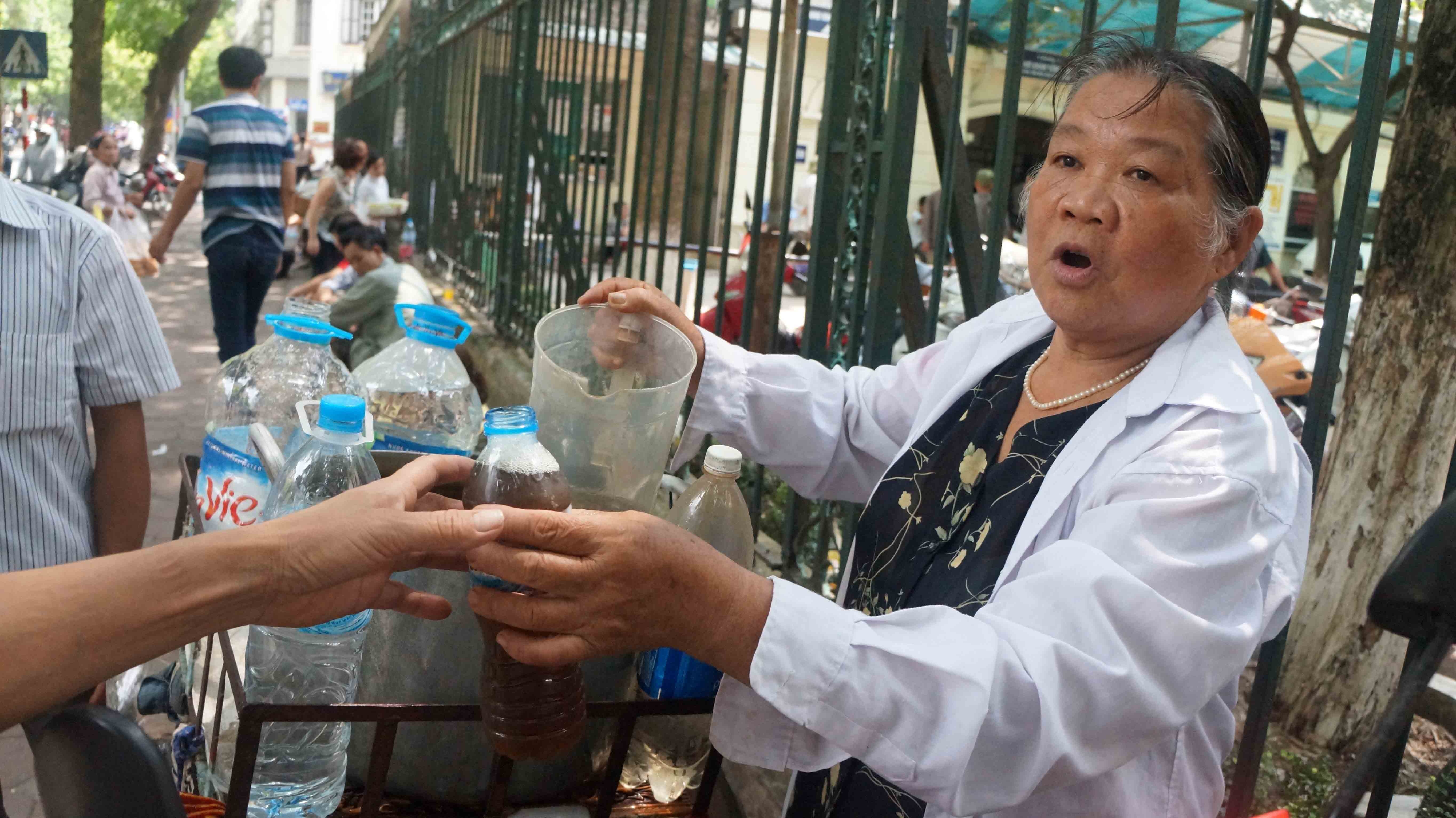 Bà Thung mời người đi đường uống nước.