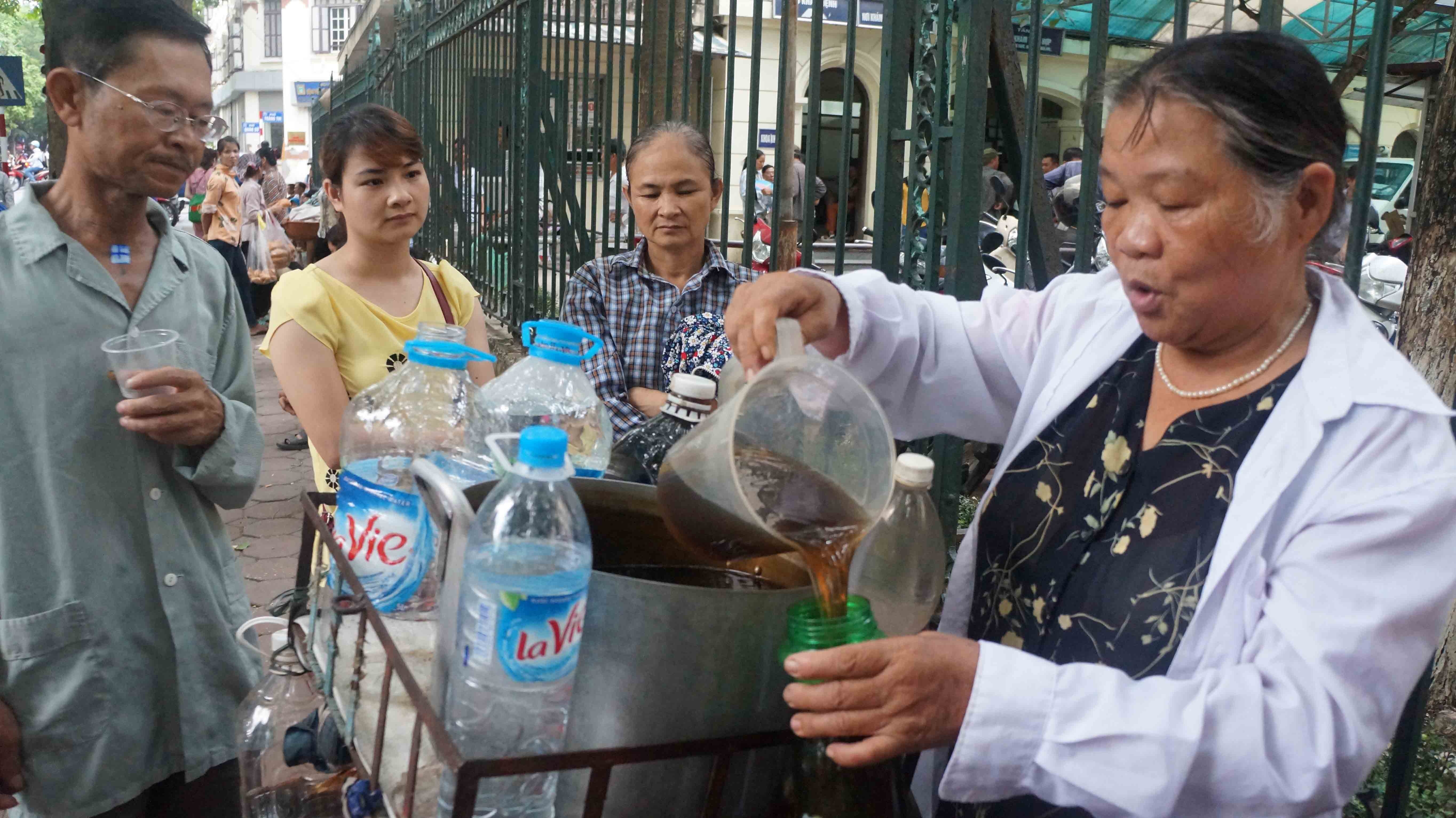 Ba lao doi nang moi nguoi dan uong nuoc mien phi hinh anh