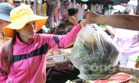 Bà nội trợ xách oằn tay với những túi ni-lông đủ màu sắc, kích cỡ.