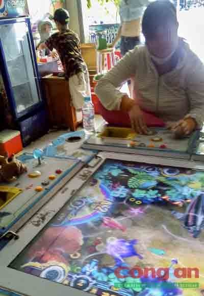 Một phụ nữ say mê chơi game bắn cá.