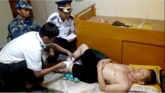 Quân y của tàu CSB 2004 đang băng vết thương cho một thủy thủ tàu Sunrise 689, trong khi sĩ quan CSB khác ghi lời khai.