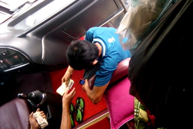 “Cò” Phước nhận tiền từ lái xe.