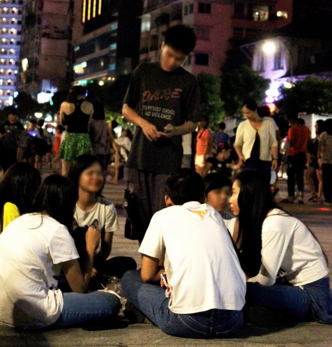 Nam thanh niên tiếp cận một nhóm bạn tại phố đi bộ Nguyễn Huệ tối 12/7.