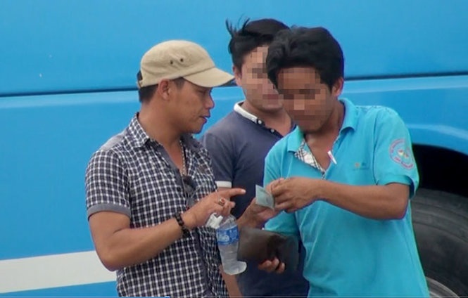 Giang “đen” (bìa trái) thu tiền xe khách trên tuyến quốc lộ 1 đoạn trước khu du lịch Suối Tiên (Q.9, TP.HCM).