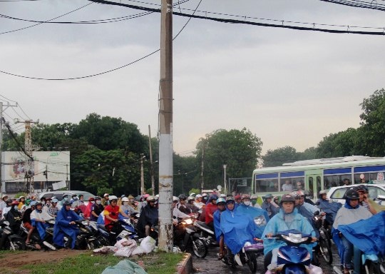 Đường Nguyễn Kiệm hướng từ ngã tư Phú Nhuận về quận Gò Vấp ùn tắc. Dòng xe ô tô nối đuôi nhau, nhích từng chút để di chuyển trong khi người đi xe máy phải leo lên vỉa hè để lưu thông.