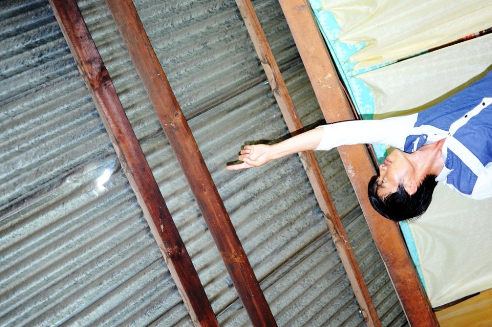 Các viên đá rơi và làm thủng mái tôn nhà người dân.