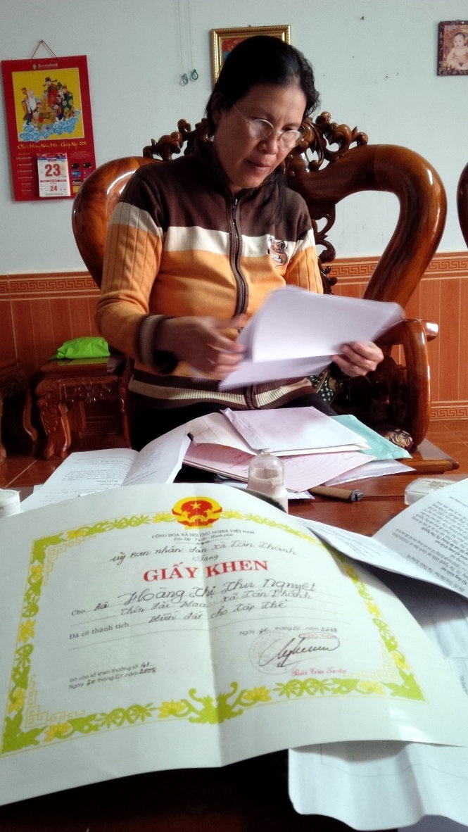 Bà Nguyệt với giấy tờ chứng minh diện tích đất của gia đình.