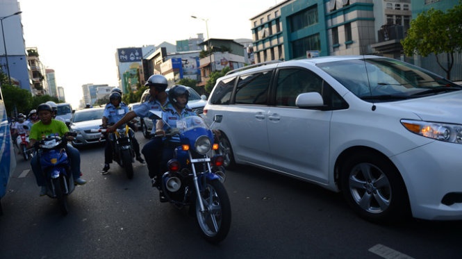 Vệ sĩ của Công ty T&T Security đi môtô giơ gậy dẹp đường (?!) bảo vệ cho đoàn xe của Nick Vujicic.