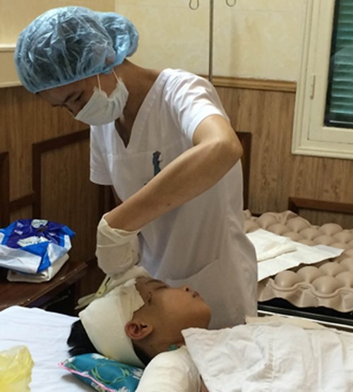 Điều dưỡng Hằng thay băng cho bệnh nhi Phong.