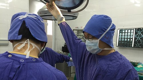 Bác sĩ, TS Ngô Mạnh Hùng (bên trái) trong 1 ca phẫu thuật sọ não.
