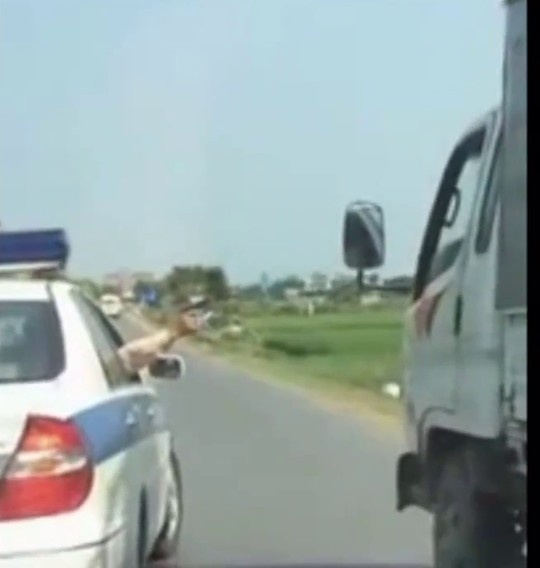 Đại úy CSGT chĩa súng về phía xe ô tô tải - Ảnh cắt từ clip.