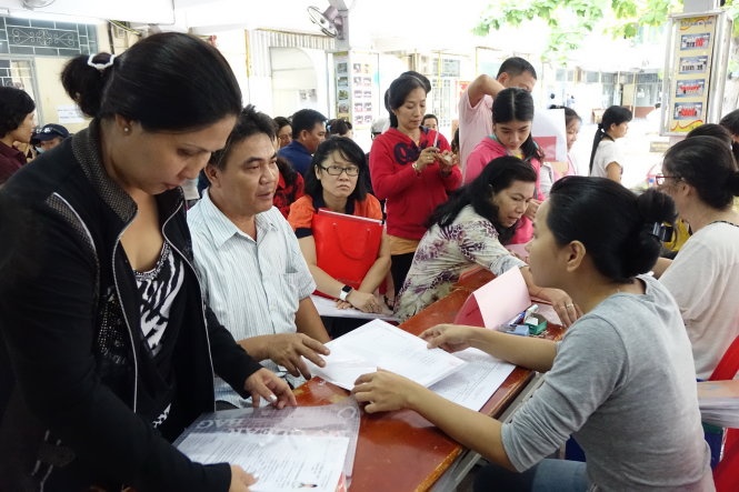 Phụ huynh đến nộp hồ sơ nhập học cho học sinh lớp 6 tại Trường THCS Kim Đồng, Q.5, TP.HCM. Đây là quận không đòi hỏi phải có hộ khẩu khi tiếp nhận học sinh.