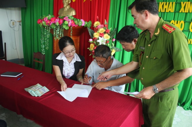 Ông Lá ký nhận tiền bồi thường oan sai.
