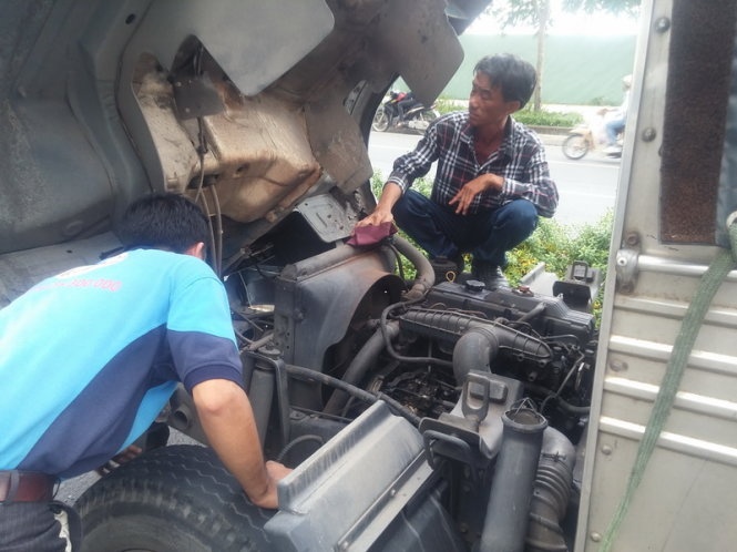 Tài xế Dưỡng cùng phụ lái đang kiểm tra xe sau khi được cứu hộ.