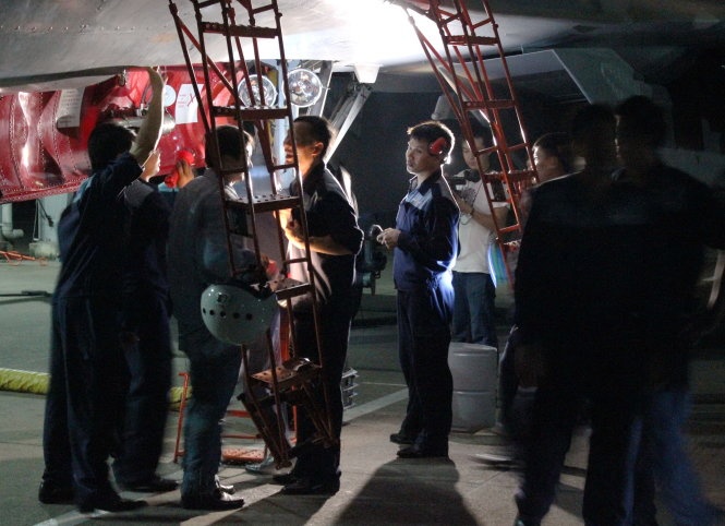 Nhân viên kỹ thuật trao đổi về tình trạng máy bay với phi công sau chuyến bay đêm.