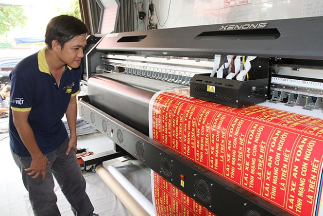 Cơ sở in của anh D. ở TP Mỹ Tho đang in số lượng lớn bảng chữ “Lái xe an toàn” cho khách hàng.
