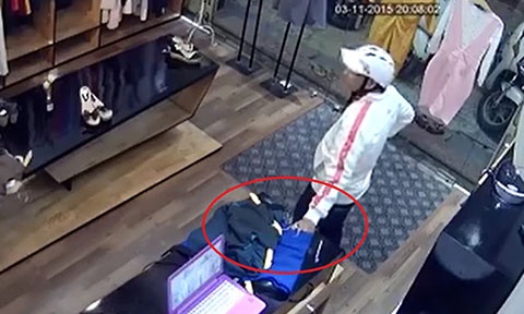 Lợi dụng chủ shop không để ý, nam thanh niên đưa tay kéo điện thoại ra ngoài.